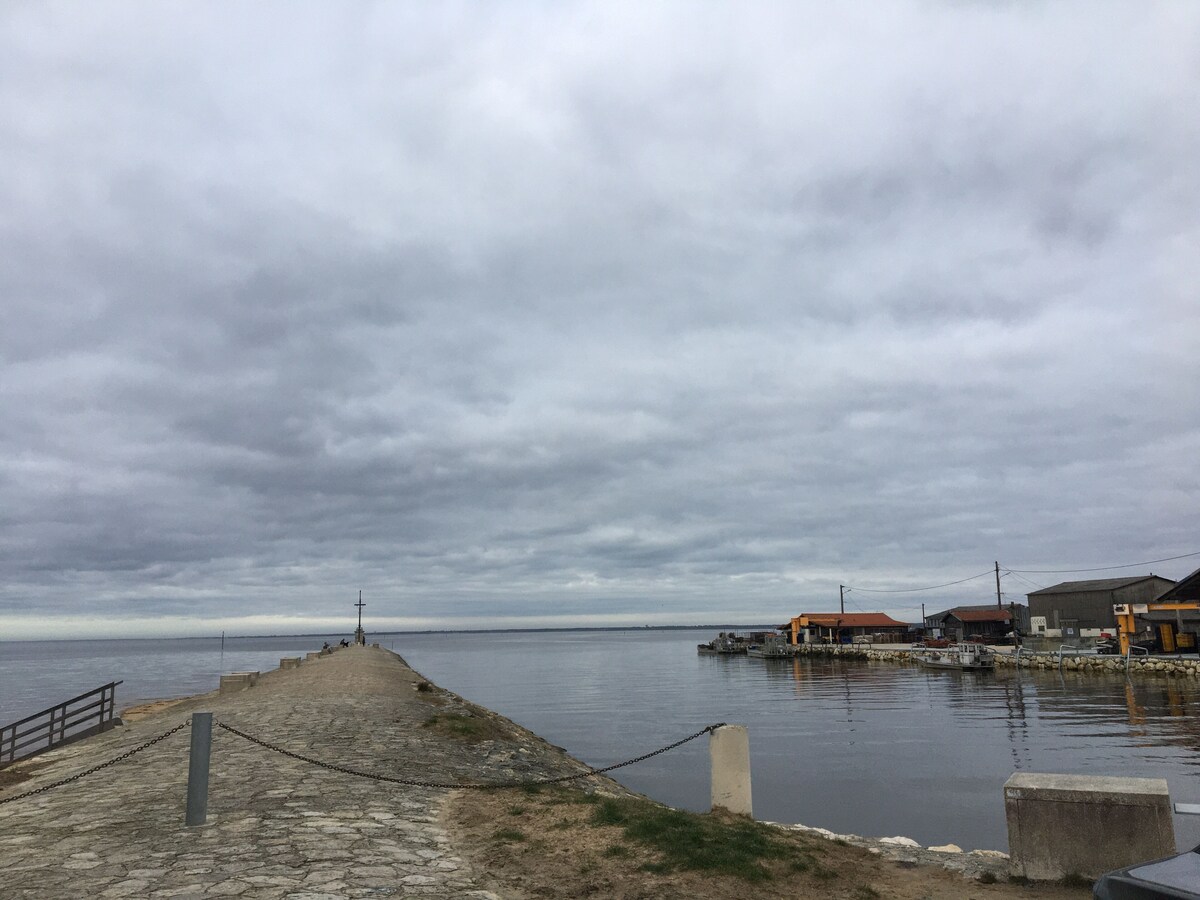 Jetée du Port du Canal s'avançant dans le Bassin d'Arcachon sous ciel nuageux — à 700 m de la villa