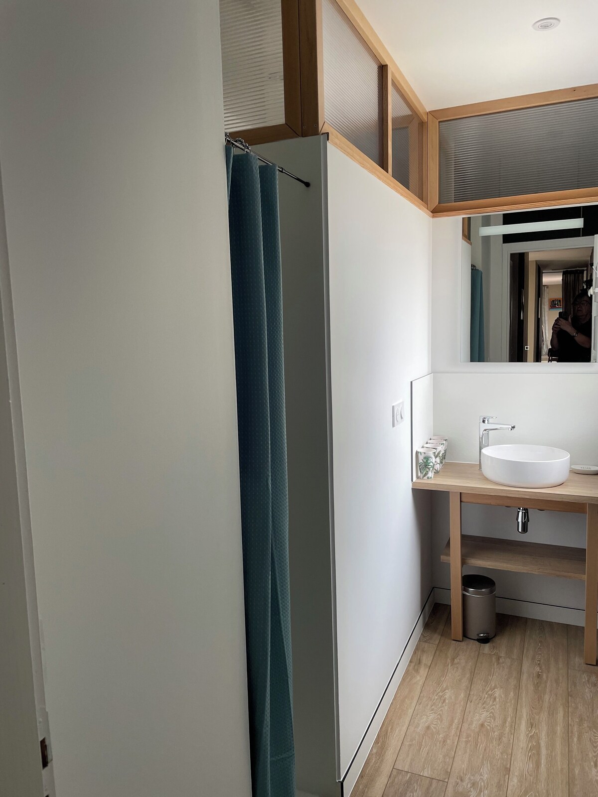 Salle de bains avec douche à l'italienne (rideau bleu canard), meuble vasque en bois et miroir — La Maison des Coccinelles