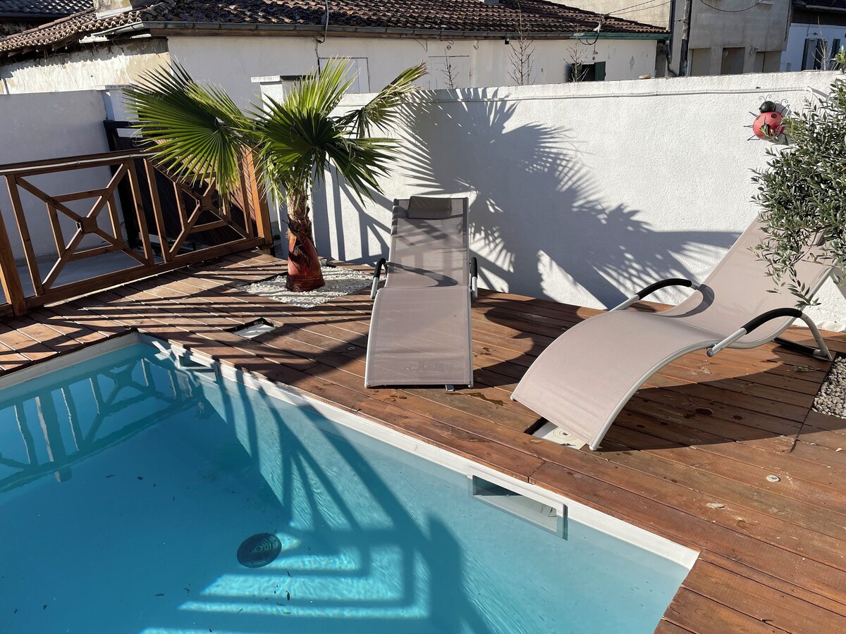 Piscine avec transat et palmier sous le soleil, terrasse en bois — La Maison des Coccinelles