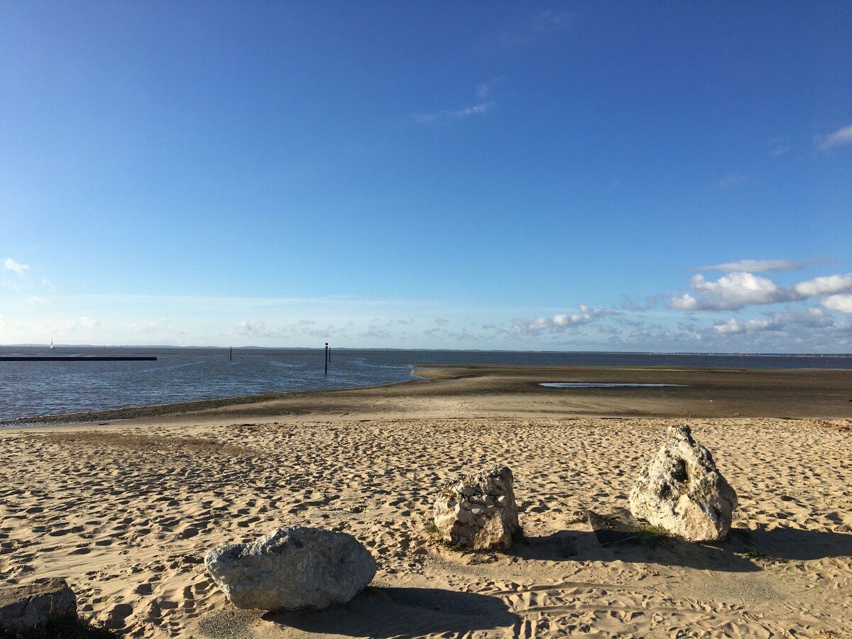 Plage de sable du Bassin d'Arcachon avec rochers sous ciel bleu — à 15 min à pied de la villa