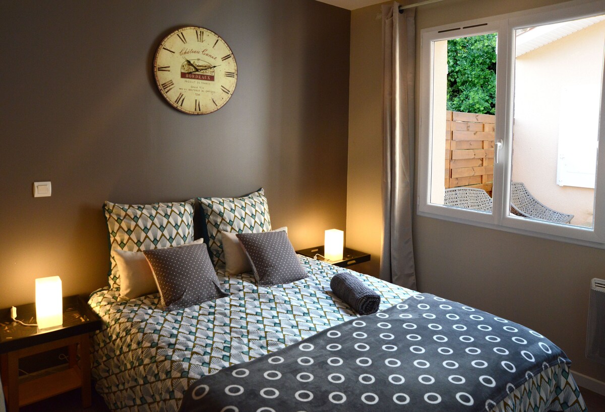 Chambre avec lit double, éclairage chaleureux et horloge vintage au mur — La Maison des Coccinelles